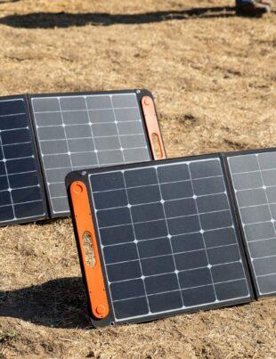 a couple of black and orange rectangular objects on a dirt surface