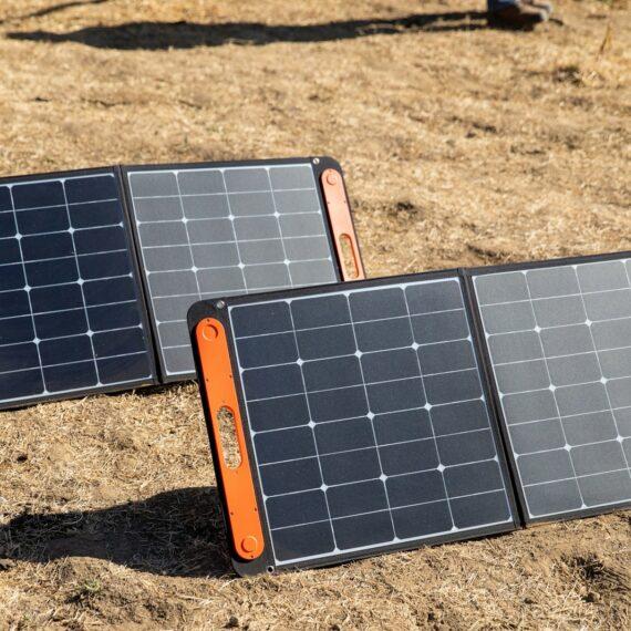 a couple of black and orange rectangular objects on a dirt surface