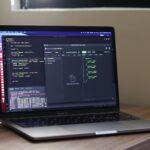 a laptop computer sitting on top of a wooden desk