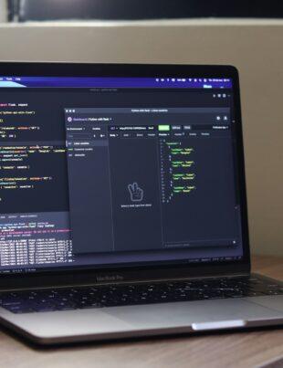 a laptop computer sitting on top of a wooden desk