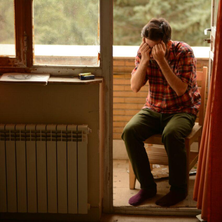 a person sitting on a chair looking out a window