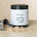 a jar of protein powder next to a scoop of powder