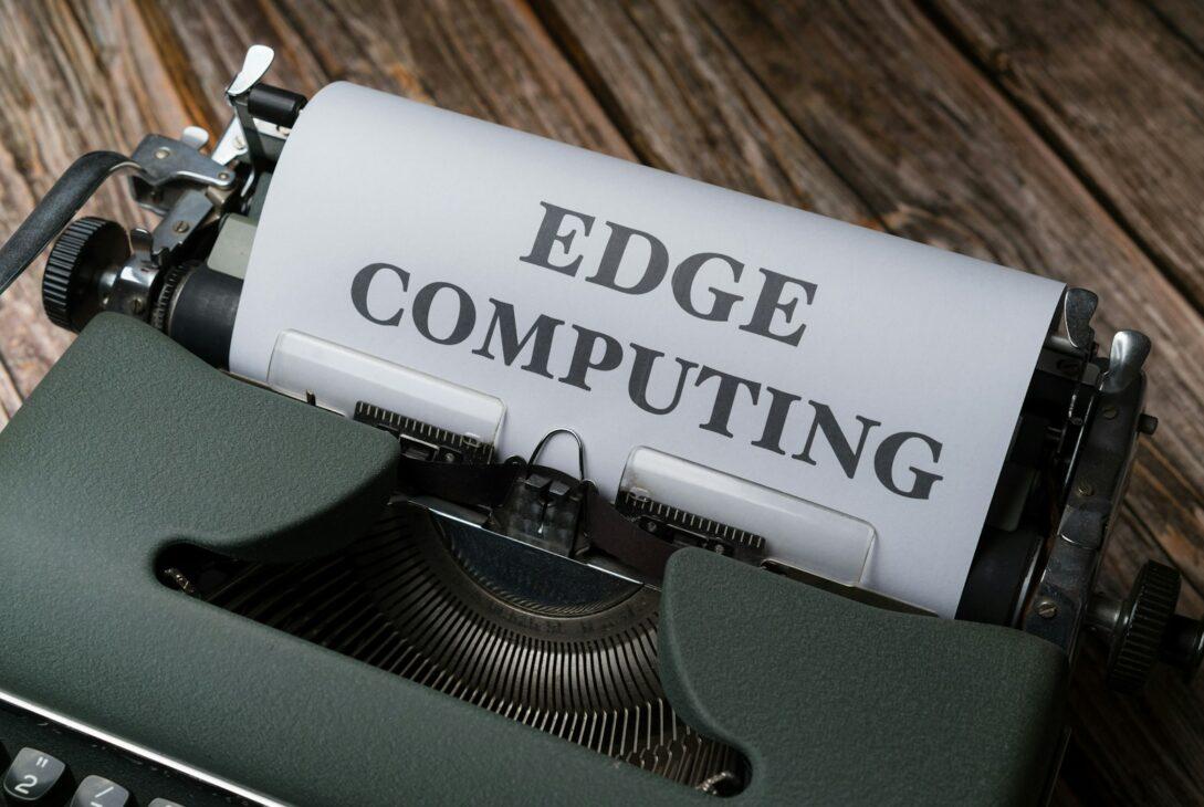 a close up of a typewriter with a paper reading edge computing