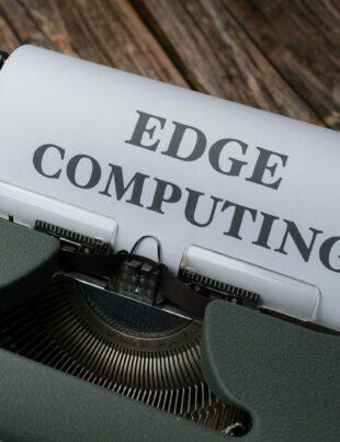 a close up of a typewriter with a paper reading edge computing