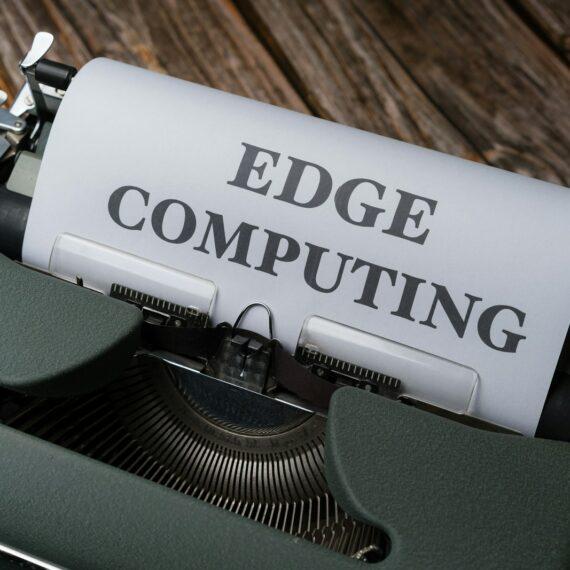 a close up of a typewriter with a paper reading edge computing