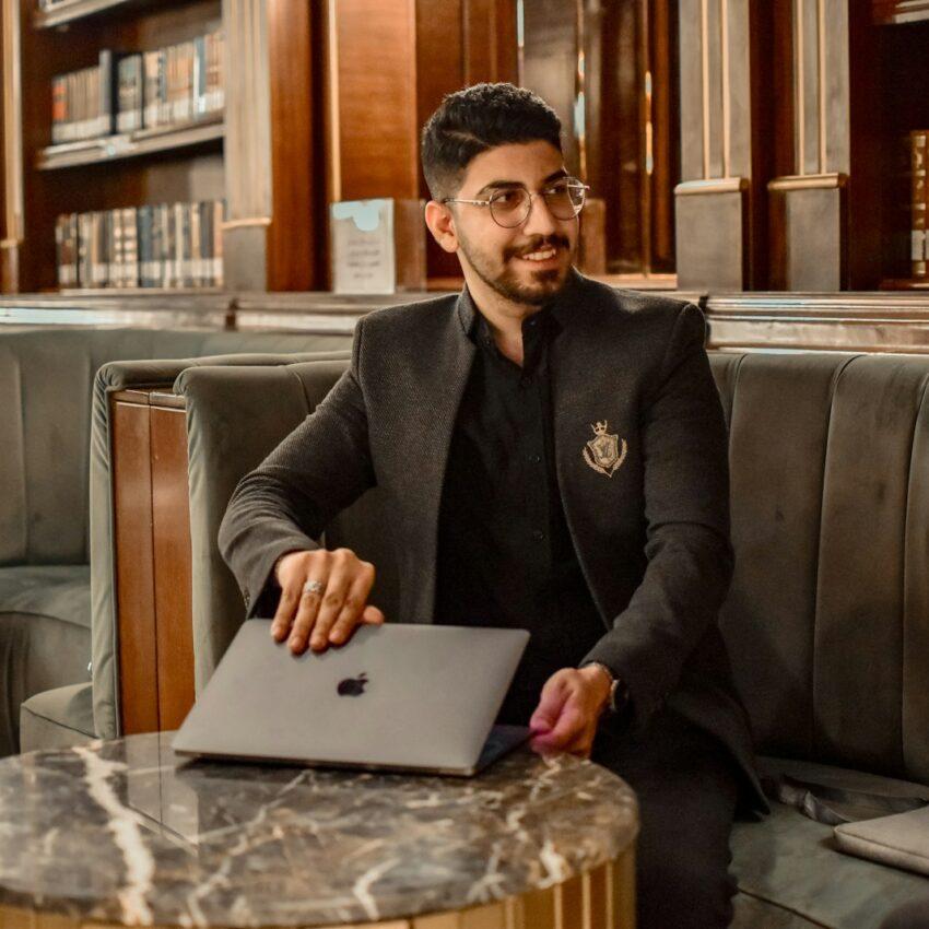 a man sitting at a table with a laptop