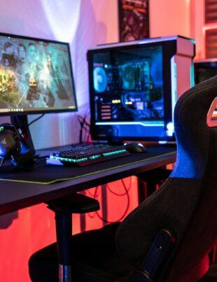 a desk with a computer and a gaming chair