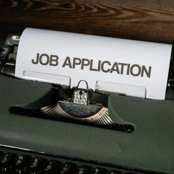 a typewriter with a job application printed on it