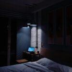 turned-on laptop computer on top of side table inside bedroom