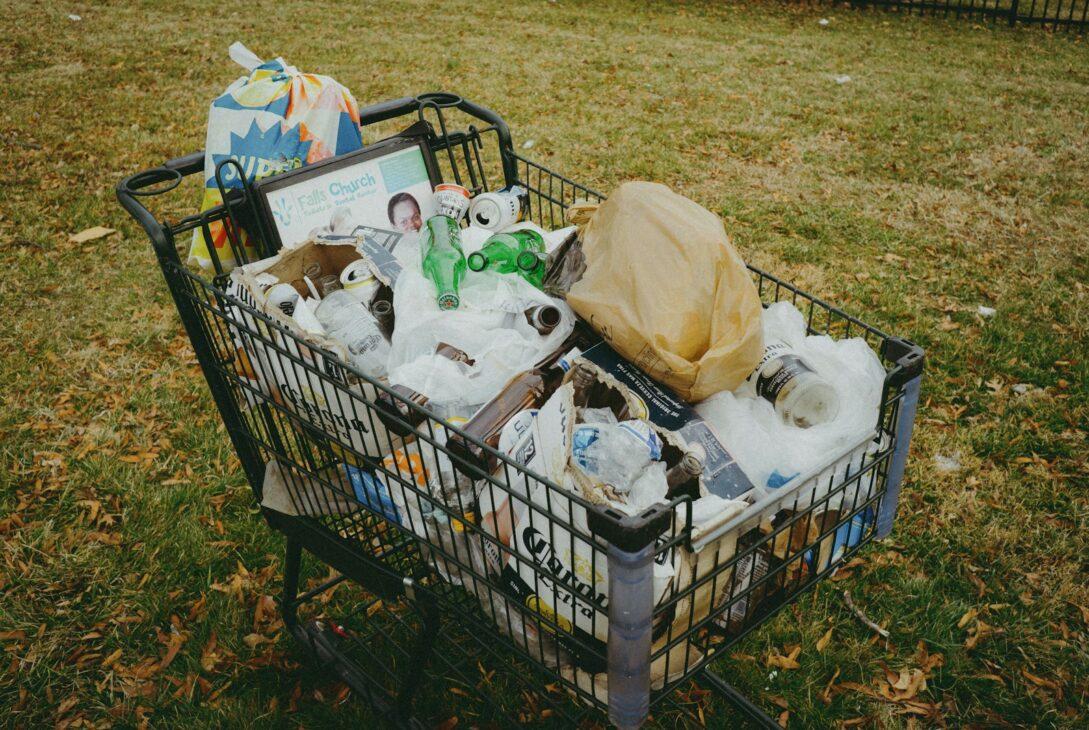 A shopping cart filled with items in a yard