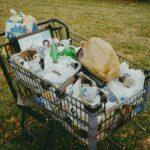 A shopping cart filled with items in a yard
