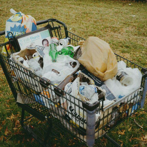A shopping cart filled with items in a yard